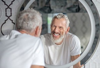 Senior man smiling at himself in mirror
