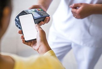 Person using phone to pay for dental treatment