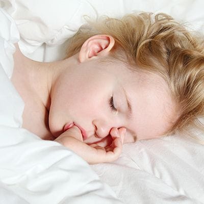Sleeping child sucking her thumb