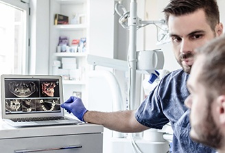 a dentist consulting with a patient and showing them their X-ray