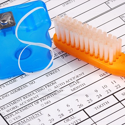 Toothbrush and floss on dental insurance forms