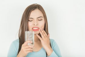 person in pain drinking ice water