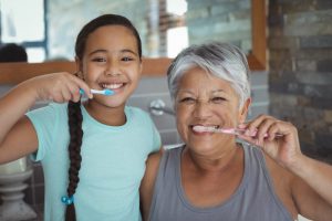 parent and child brushing their teeth together