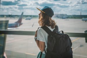 person looking out a window at an airport