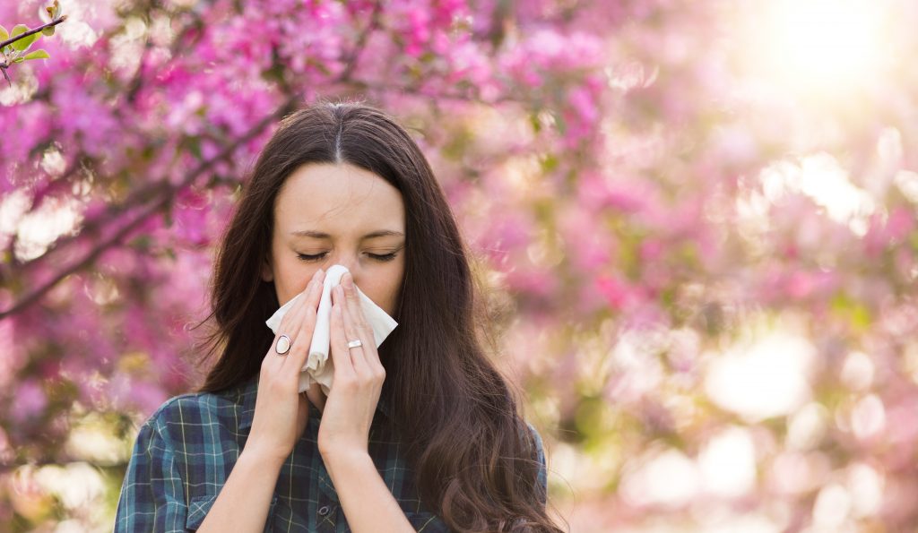 woman sick blowing her nose