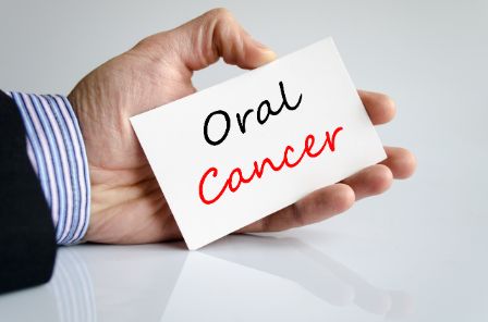 Someone holding a card that reads, Oral Cancer