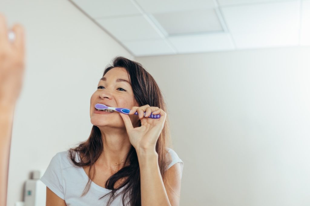 Closeup of woman brushing her teeth