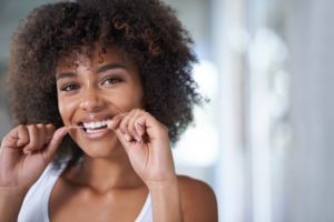 woman flossing for her New Year’s resolution