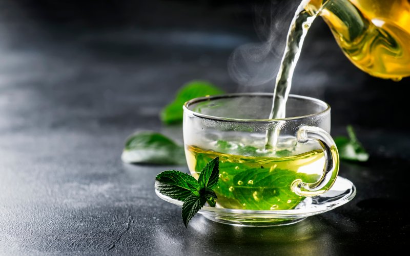 a glass of green tea being poured