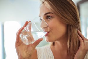 a person drinking a glass of water 