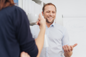 a person smiling and gesturing during a conversation